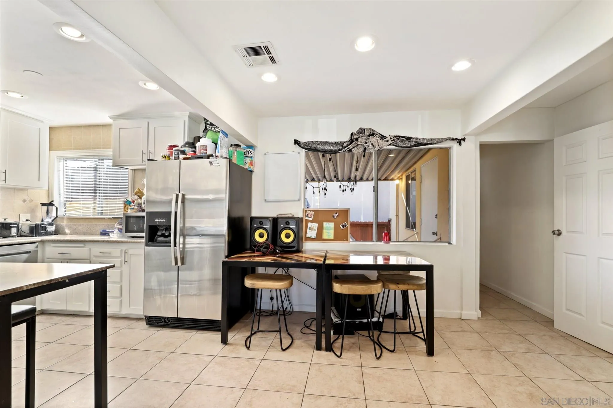 1633 Thomas Avenue San Diego, CA 92109 - Photo 25 of 48 a kitchen with stainless steel appliances a refrigerator a stove a sink and chairs