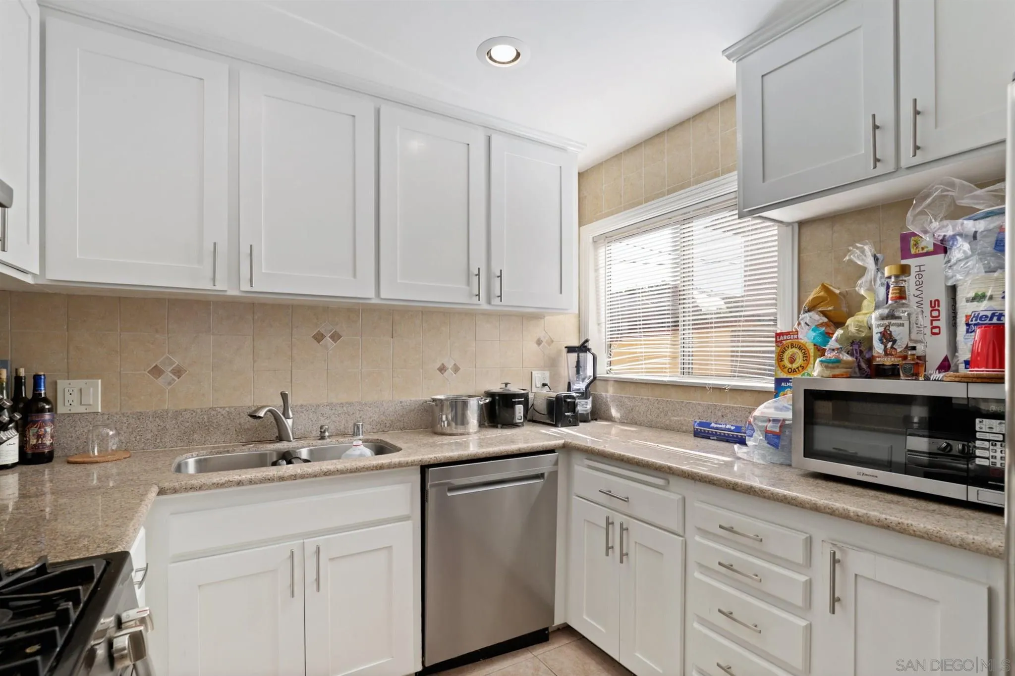 1633 Thomas Avenue San Diego, CA 92109 - Photo 27 of 48 a kitchen with stainless steel appliances granite countertop a sink a stove and cabinets