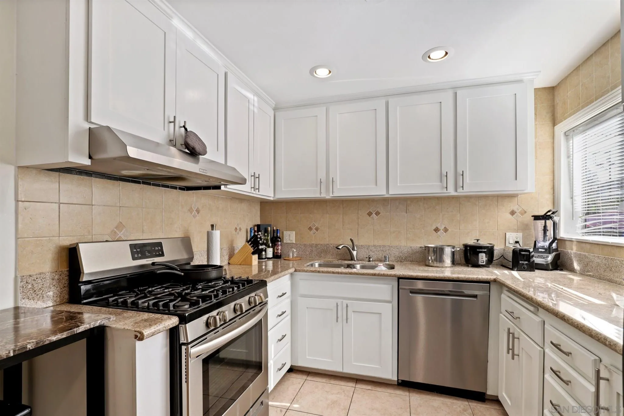 1633 Thomas Avenue San Diego, CA 92109 - Photo 28 of 48 a kitchen with stainless steel appliances granite countertop a stove a sink and a white cabinets