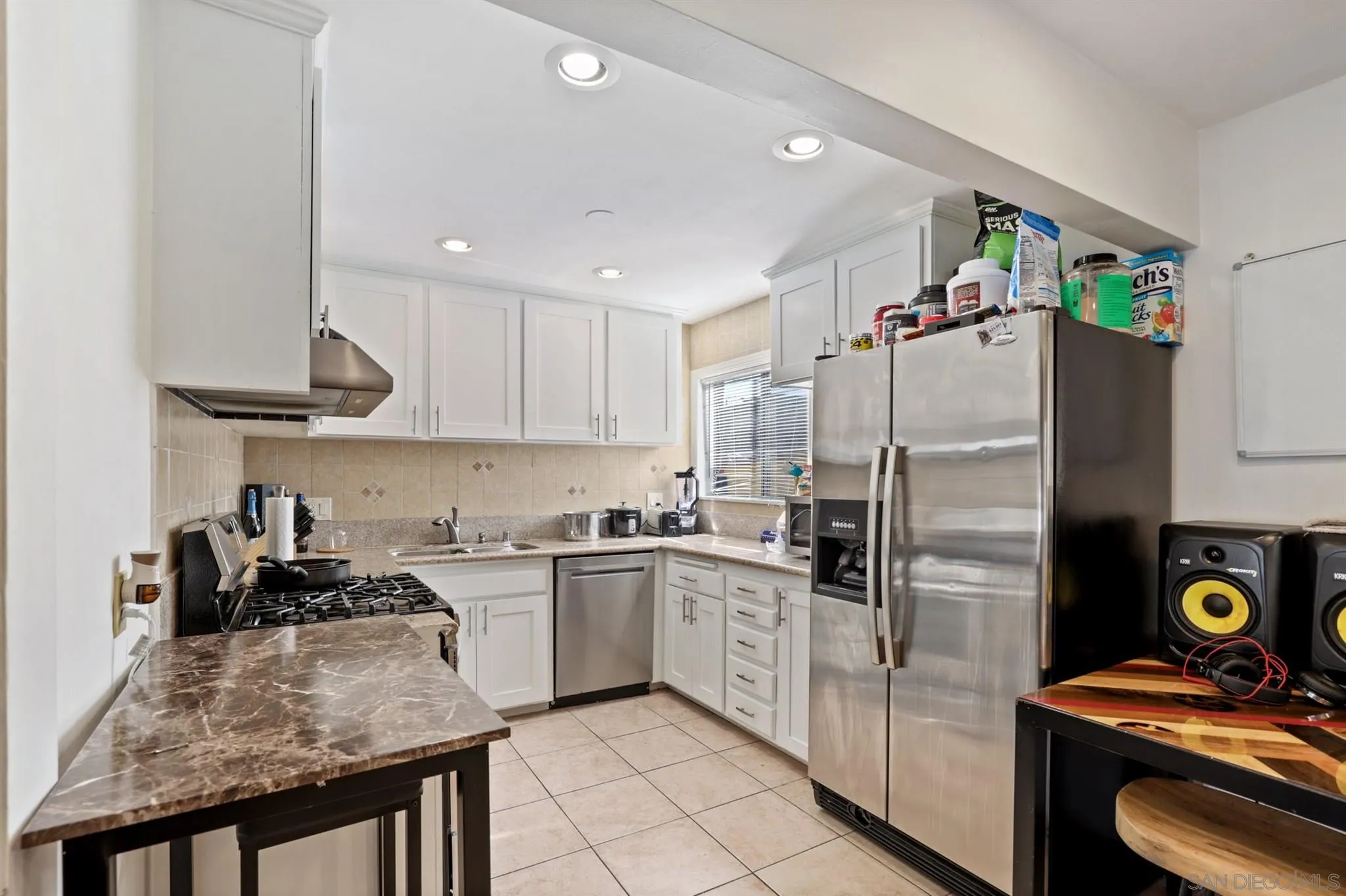 1633 Thomas Avenue San Diego, CA 92109 - Photo 29 of 48 a kitchen with stainless steel appliances granite countertop a sink stove and refrigerator