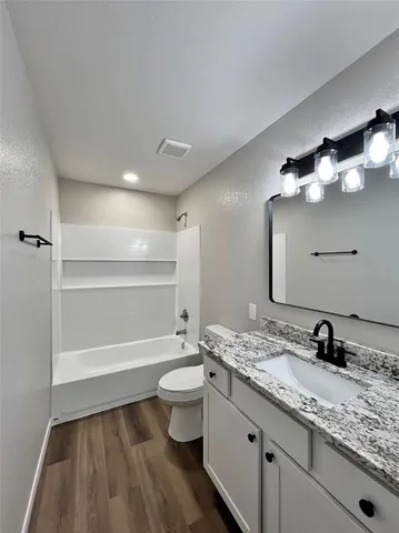 a bathroom with a granite countertop sink toilet a large mirror and shower