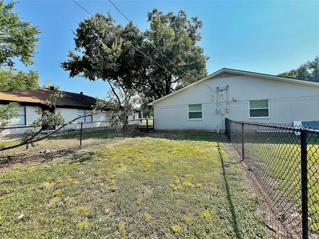 a backyard of a house with table and chairs