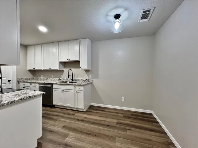 a kitchen with granite countertop white cabinets and white appliances