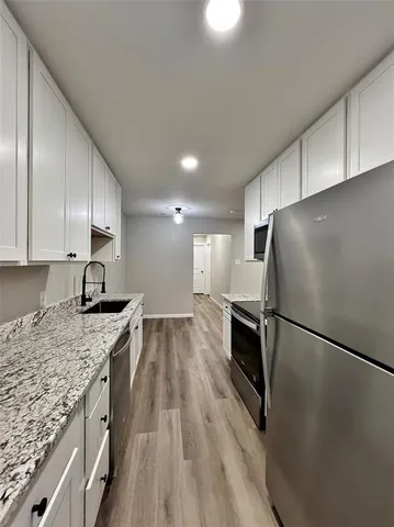 a kitchen with a sink a refrigerator and a stove top oven