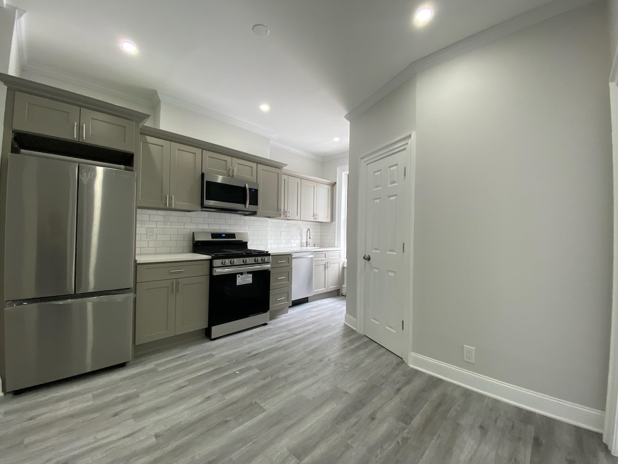 338 2nd Street, Unit 2 Jersey City, NJ 07302 - Photo 3 of 9 a kitchen with a refrigerator and a stove top oven