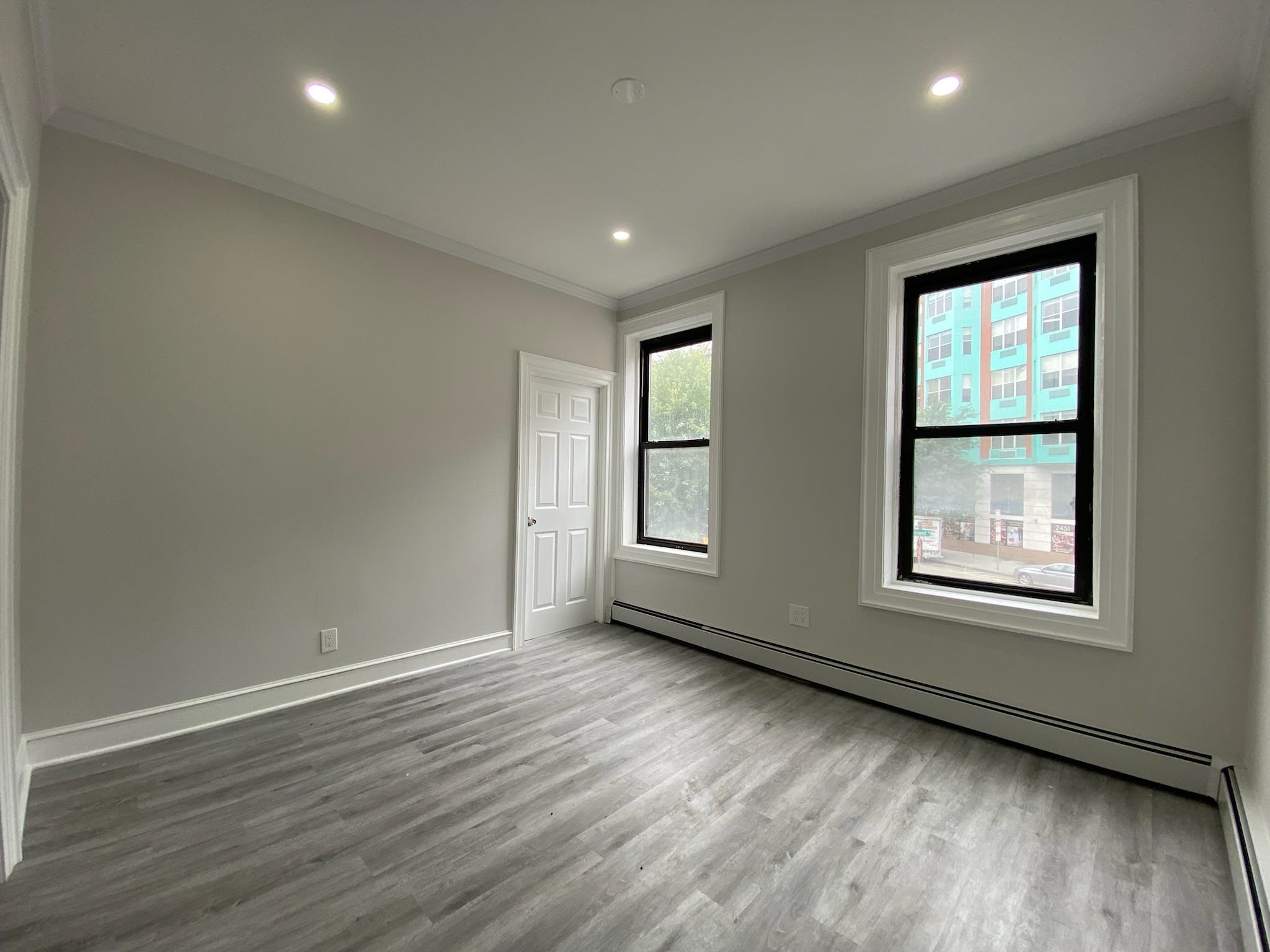 338 2nd Street, Unit 2 Jersey City, NJ 07302 - Photo 5 of 9 a view of an empty room with wooden floor and a window