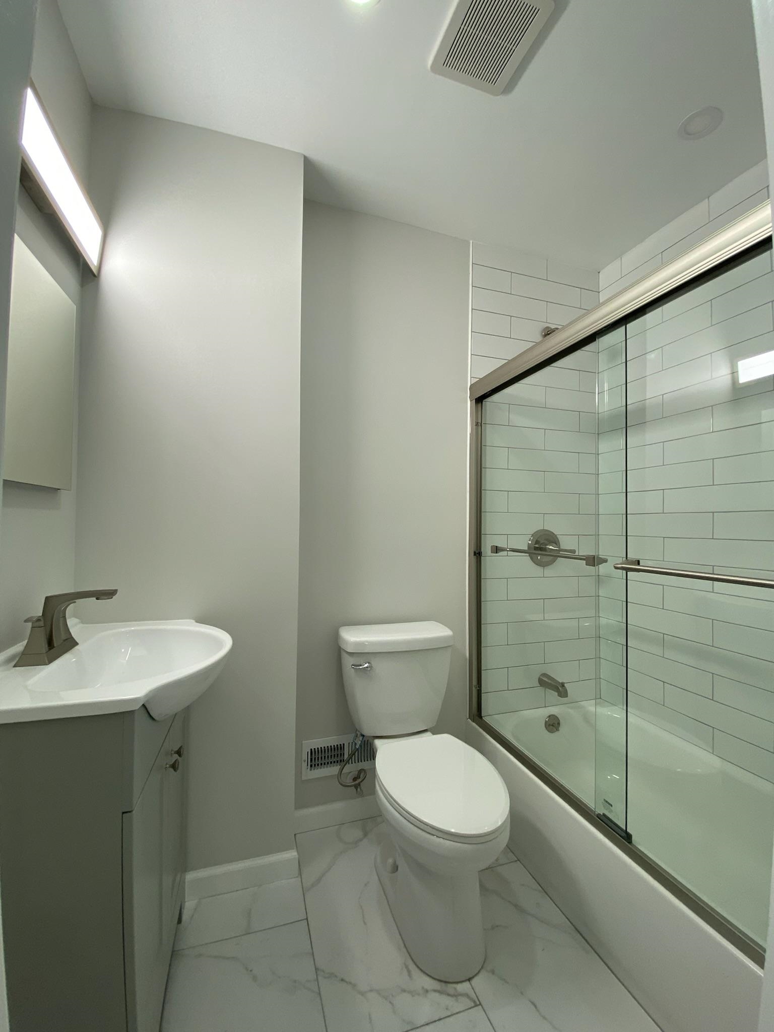 338 2nd Street, Unit 2 Jersey City, NJ 07302 - Photo 7 of 9 a bathroom with a toilet a sink and shower