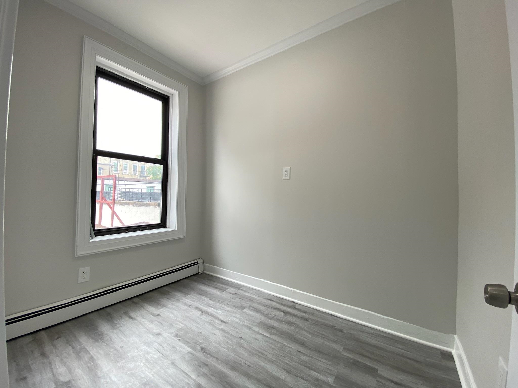 338 2nd Street, Unit 2 Jersey City, NJ 07302 - Photo 8 of 9 an empty room with wooden floor and windows