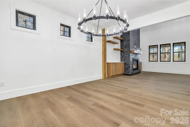 a view of empty room with wooden floor and window