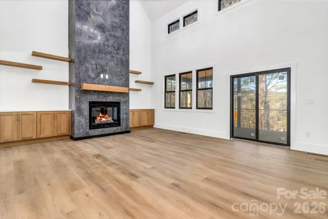 an empty room with windows and fireplace