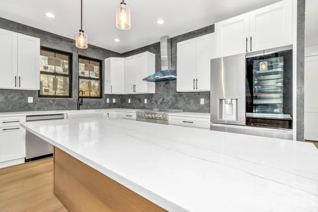 a large kitchen with stainless steel appliances kitchen island granite countertop a stove and a sink with granite countertops