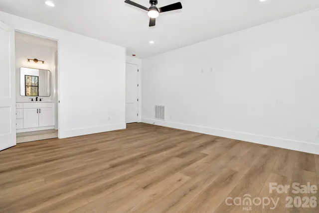 an empty room with wooden floor and mirror