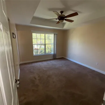 an empty room with a ceiling fan and window