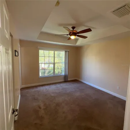 an empty room with windows and fan
