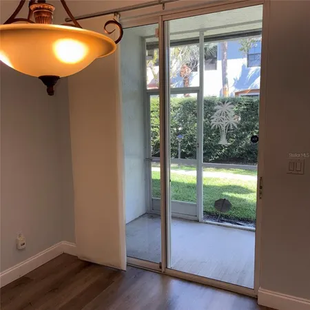 a view of an empty room and wooden floor and windows