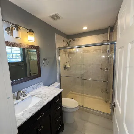 a bathroom with a granite countertop sink toilet and shower
