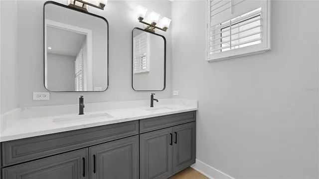 a bathroom with double vanity sink and a mirror