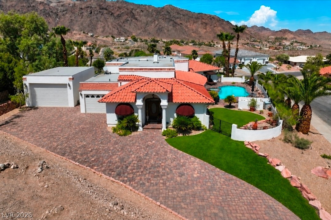 102 Red Rock Road Boulder City, NV 89005 - Photo 1 of 1 A terracotta tiled roof and sprawling paver driveway frame this desert estate with mountain backdrops.