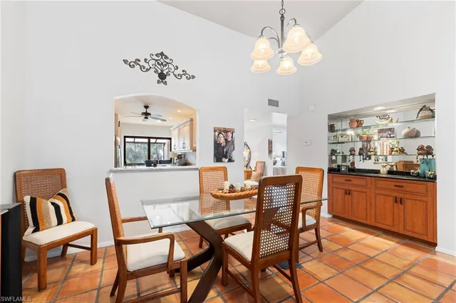 a dining room with wooden floor a chandelier a glass table and chairs