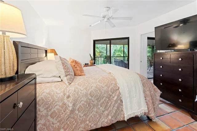 a spacious bedroom with a bed and a flat tv screen on dresser