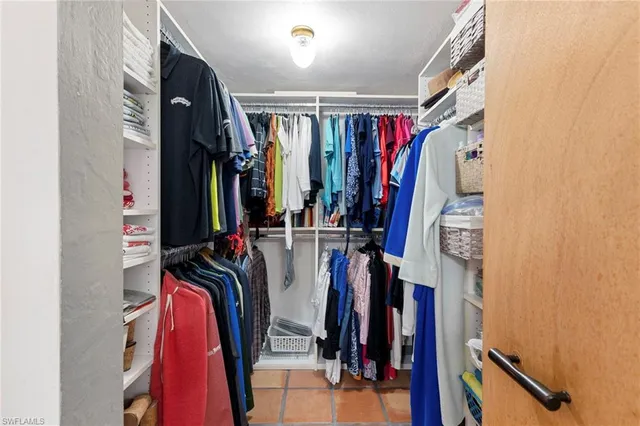 a view of walk in closet with clothes