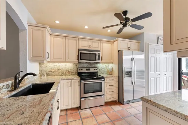 a kitchen with stainless steel appliances a stove a sink and a refrigerator