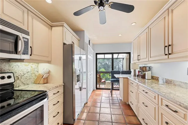 a kitchen with stainless steel appliances granite countertop a stove a sink and a refrigerator