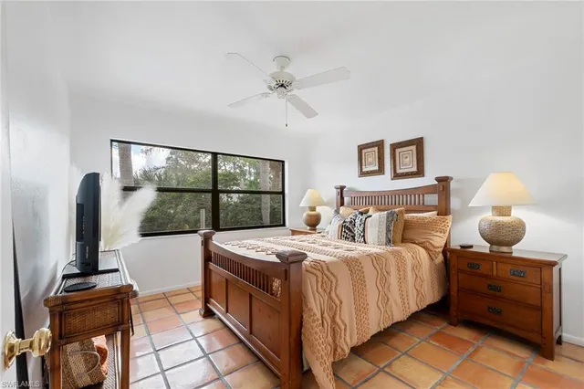 a bedroom with a bed and large windows