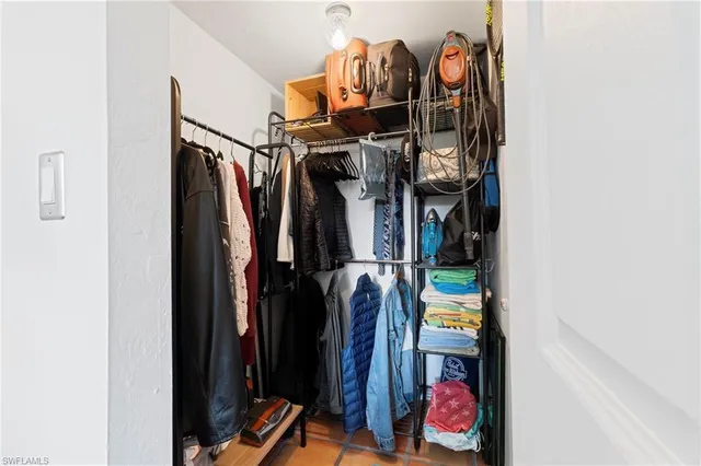 a view of walk in closet with clothes and shoes