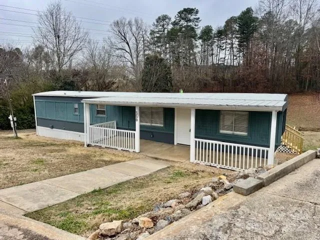 a view of a house with a yard and wooden fence