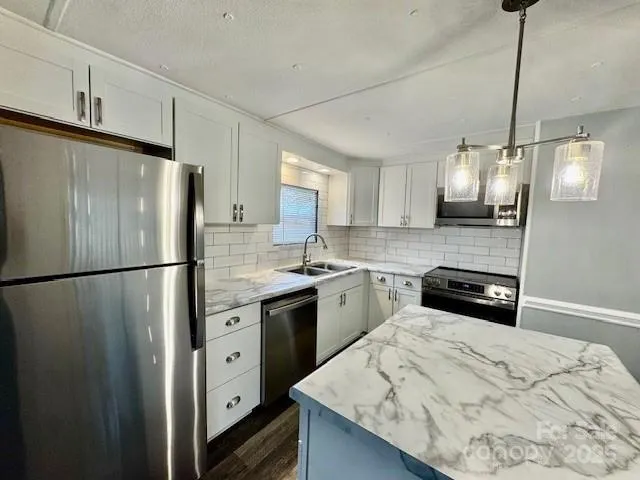 a kitchen with stainless steel appliances a refrigerator sink and wooden floor