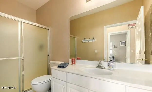 a bathroom with a granite countertop sink toilet a mirror and shower