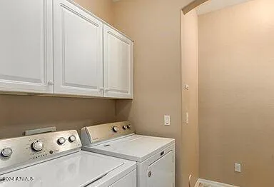 a view of washer and dryer with bathroom in the background