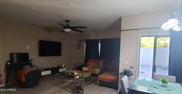a living room with furniture a ceiling fan and a flat screen tv