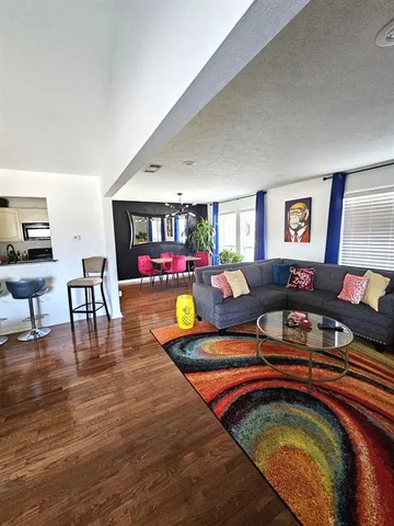 a living room with furniture and wooden floor