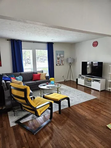 a living room with furniture a flat screen tv and a window