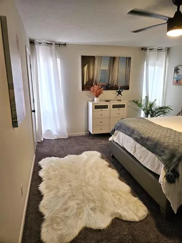 a spacious bedroom with a bed and a mirror