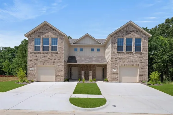 a front view of a house with yard and garage