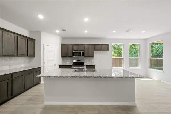 a kitchen with a sink stainless steel appliances and counter space