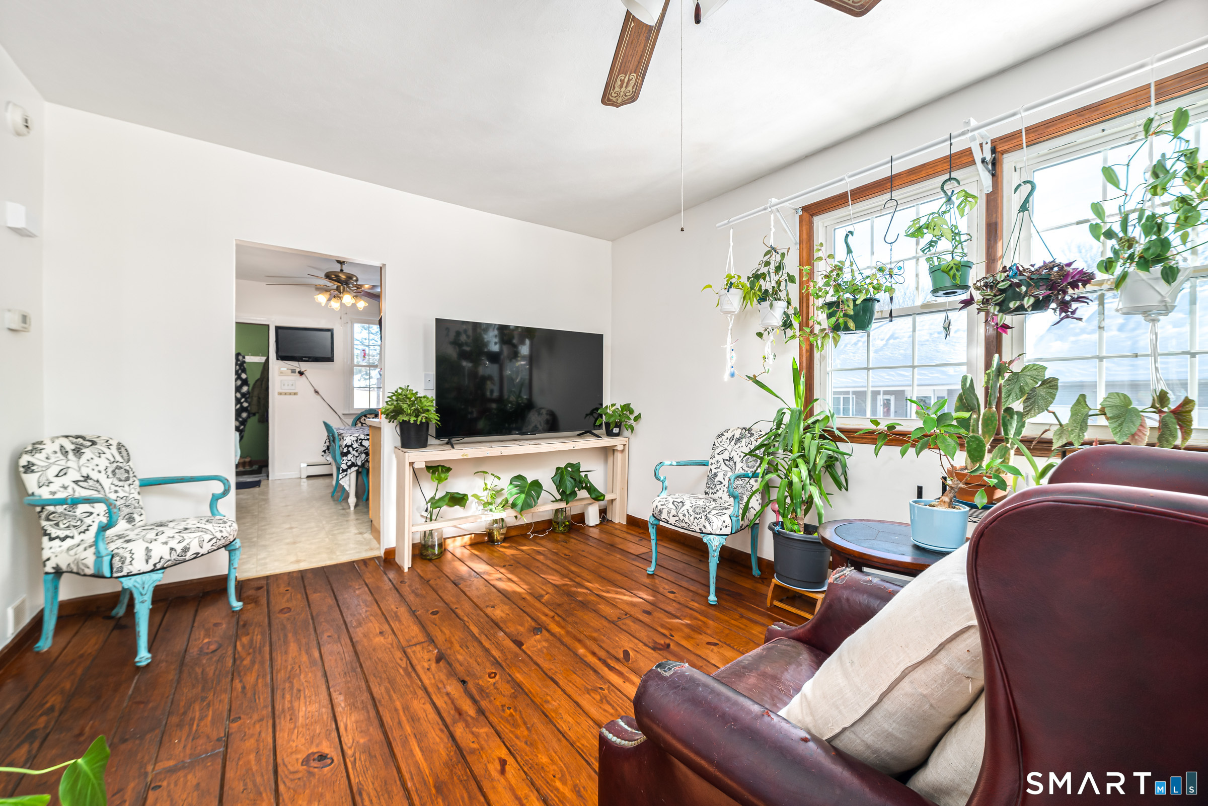11 Willard Avenue Enfield, CT 06082 - Photo 9 of 30 a living room with furniture a flat screen tv and a floor to ceiling window