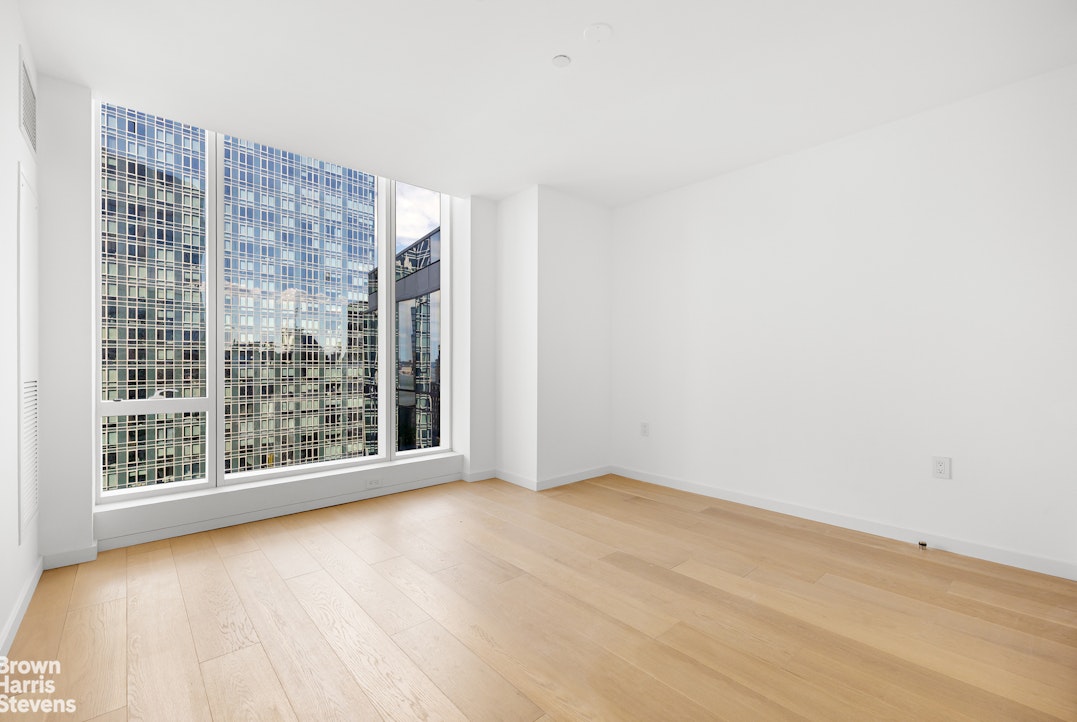 1 West End Avenue, Unit 28H Manhattan, NY 10069 - Photo 12 of 20 a view of an empty room with wooden floor and a window