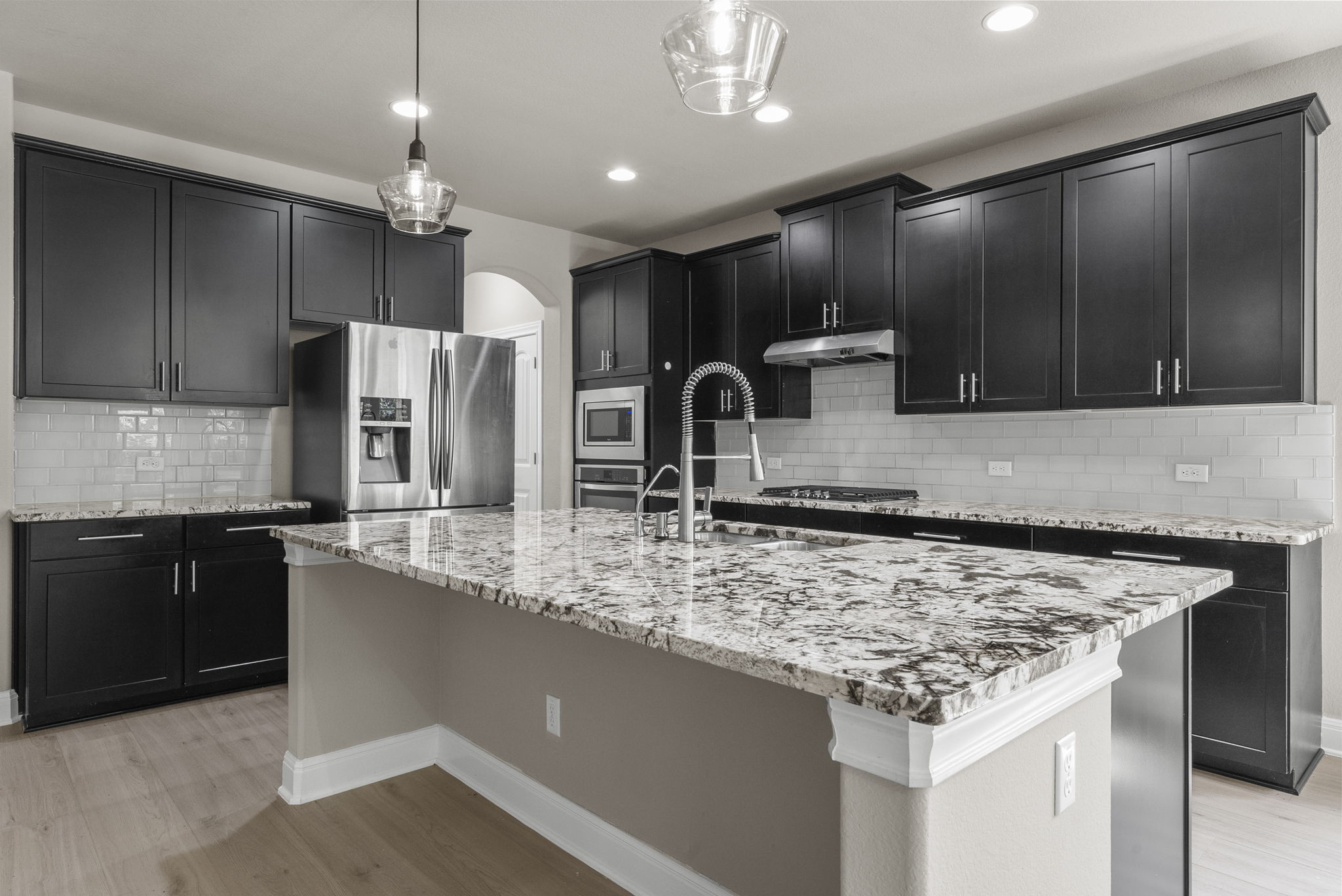 4401 Trinity Woods Street Leander, TX 78641 - Photo 13 of 37 An inviting kitchen features an elegant granite island and sleek stainless-steel appliances.