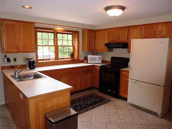 12 Nehemiah Road Shirley, MA 01464 - Photo 2 of 17 a kitchen with a sink a refrigerator a stove top oven and a window