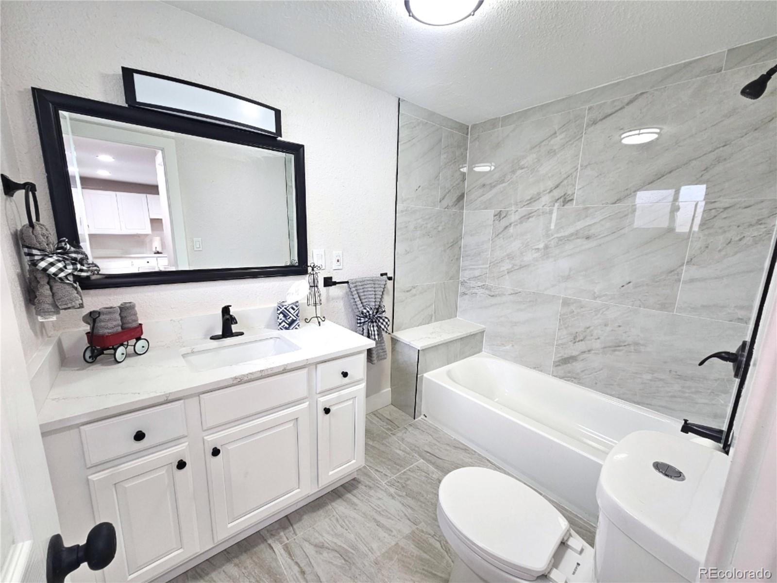 124 South Grove Street Denver, CO 80219 - Photo 7 of 25 a bathroom with a sink a toilet and a mirror