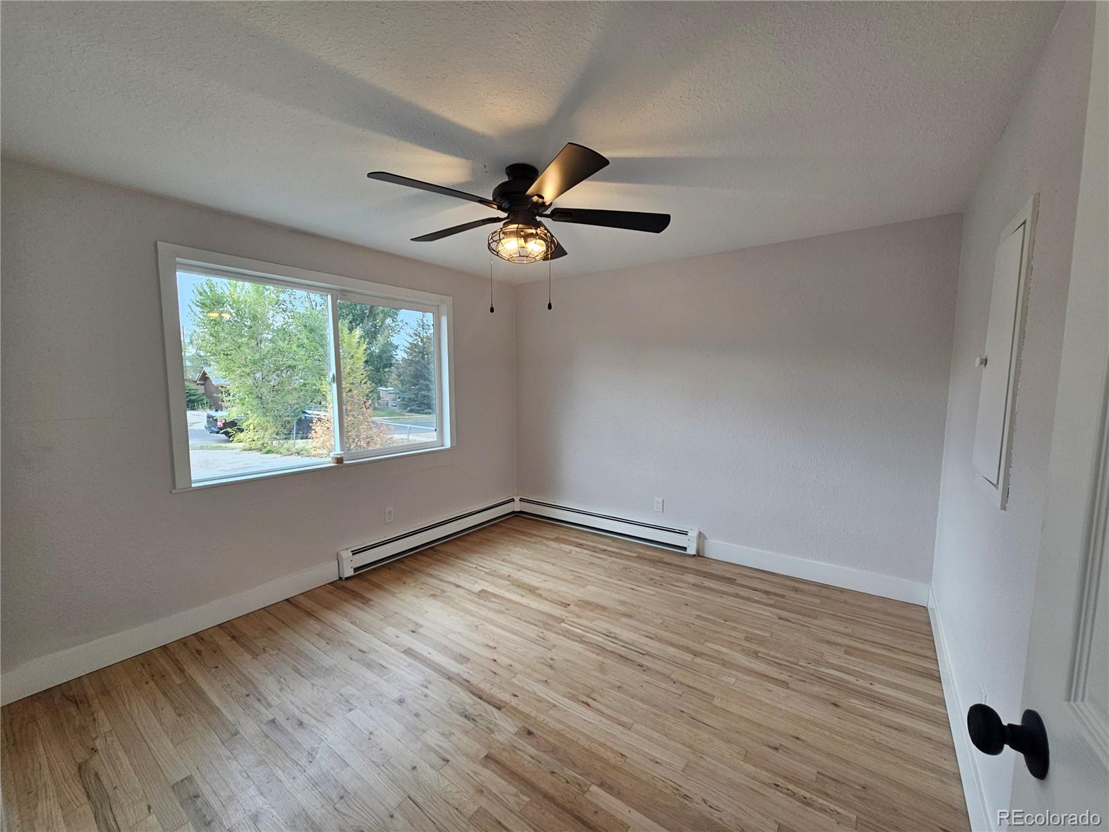 124 South Grove Street Denver, CO 80219 - Photo 10 of 25 wooden floor in an empty room with a window