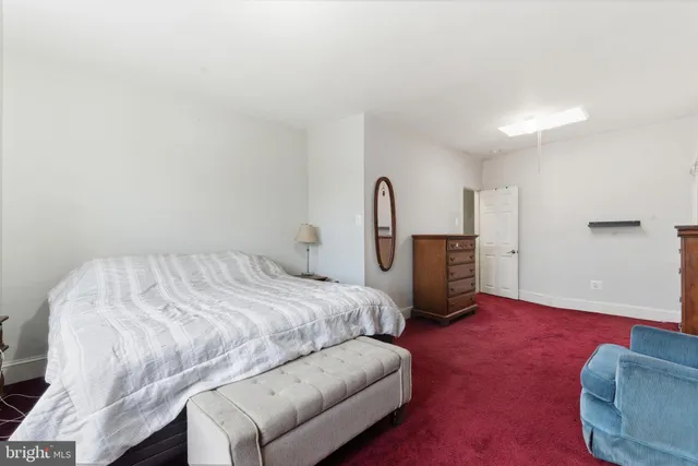 a spacious bedroom with a bed and a dresser