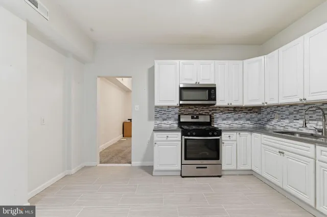 a kitchen with granite countertop a stove and a sink