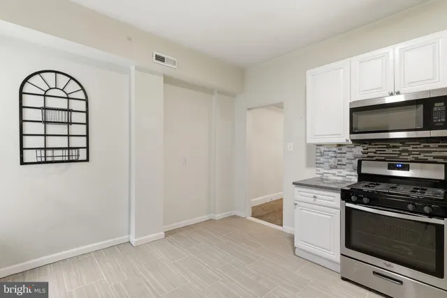 a kitchen with granite countertop a stove and a microwave