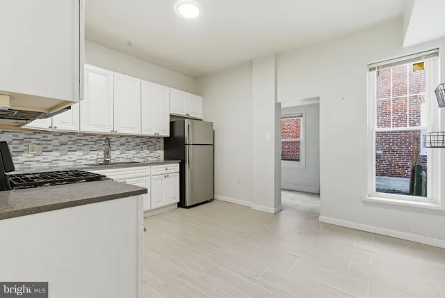 a kitchen with stainless steel appliances granite countertop a refrigerator a stove a sink and a microwave