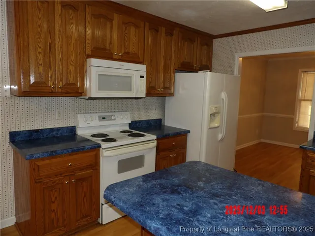 a kitchen with granite countertop a refrigerator stove and sink